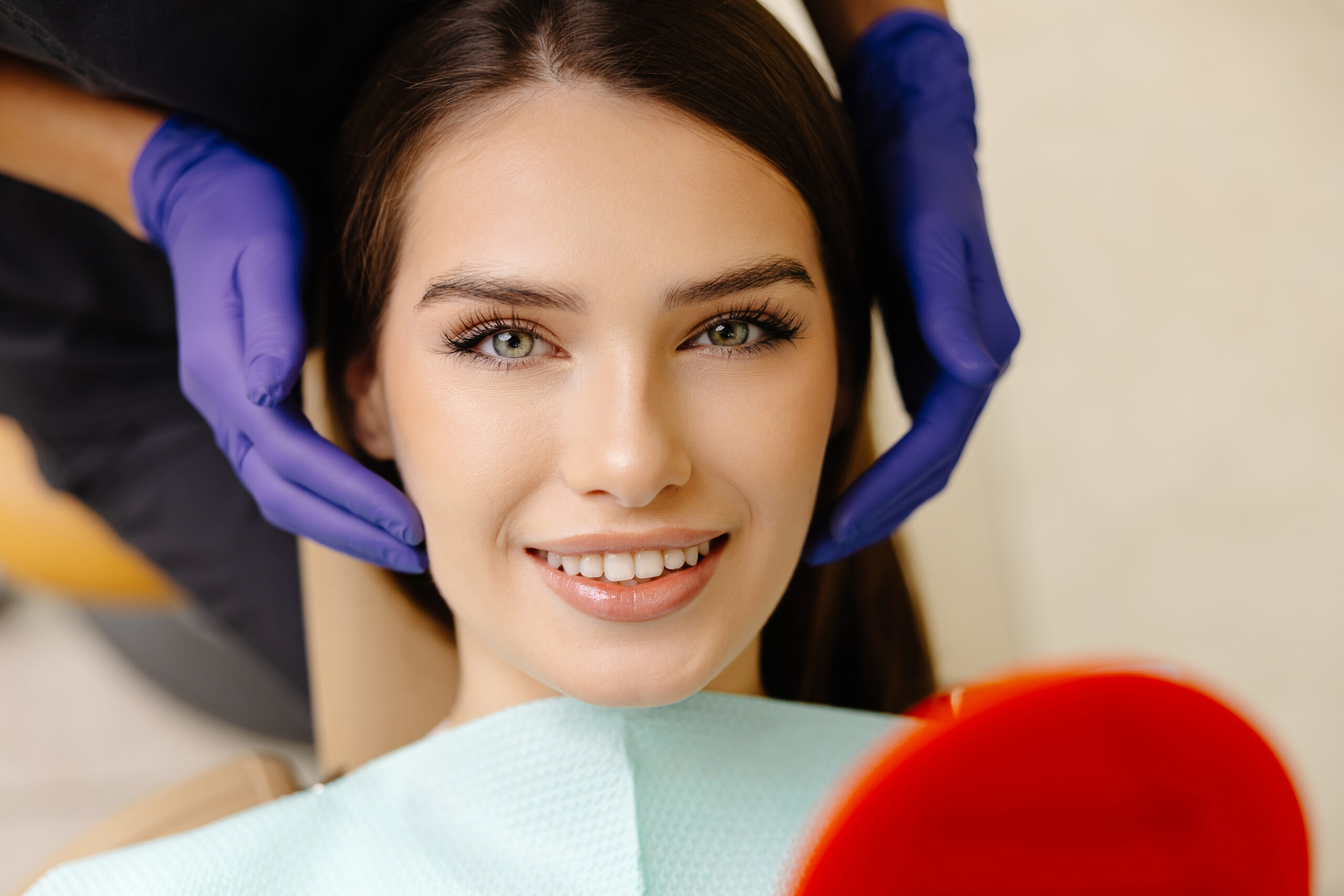 Patient smiling during cosmetic dentistry consultation while dentist evaluates facial symmetry and smile balance.